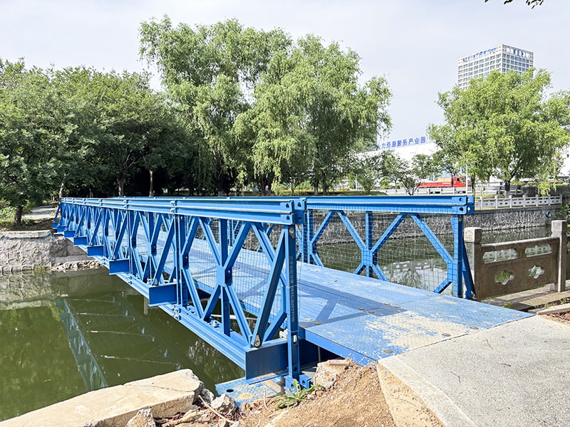 24 meter lange, blauw geschilderde, corrosiewerende, enkele rij, enkellaags versterkte voetgangersbrug Bailey